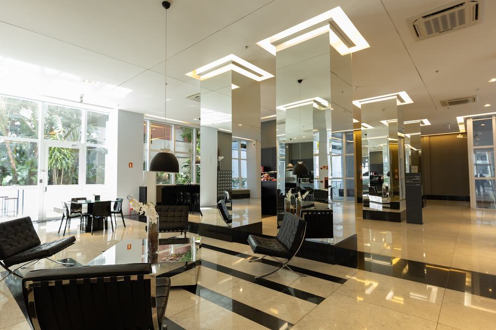 Lobby do edifício, com espaço de espera e vista para o jardim